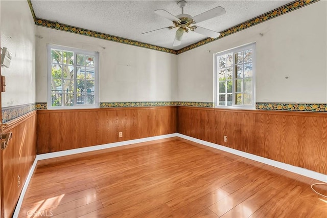 spare room with plenty of natural light, wood-type flooring, and a textured ceiling