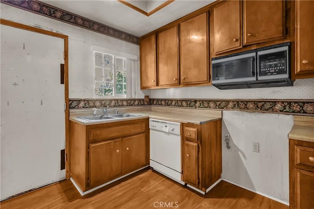 kitchen featuring sink, white dishwasher, and light hardwood / wood-style floors