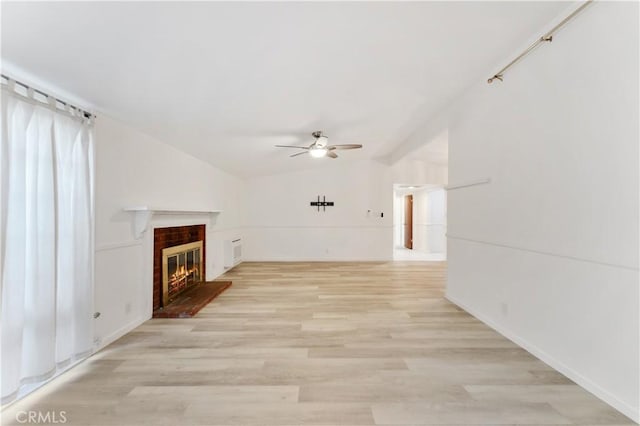 unfurnished living room featuring ceiling fan, a fireplace, lofted ceiling, and light hardwood / wood-style flooring