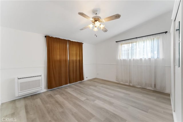 spare room with ceiling fan, light hardwood / wood-style flooring, and vaulted ceiling