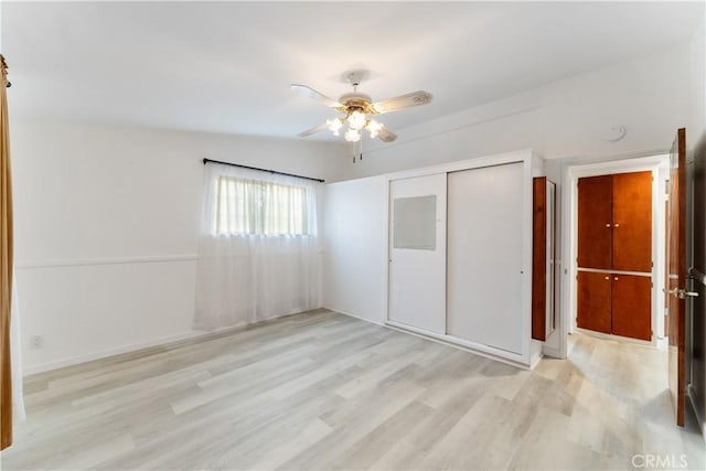 unfurnished bedroom with ceiling fan, lofted ceiling, light wood-type flooring, and a closet