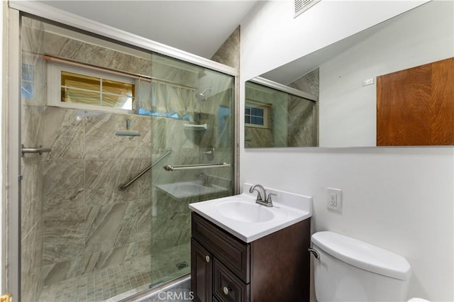 bathroom featuring vanity, toilet, and a shower with shower door