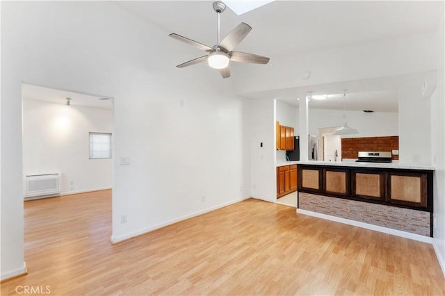 unfurnished living room with light wood-type flooring, high vaulted ceiling, ceiling fan, and sink