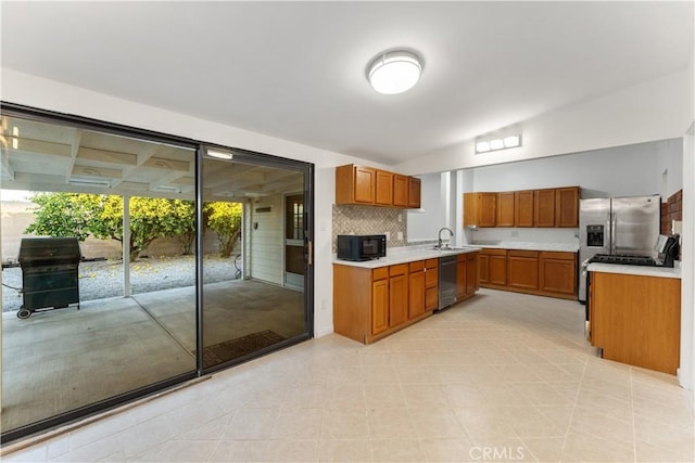 kitchen featuring sink, vaulted ceiling, decorative backsplash, light tile patterned floors, and stainless steel appliances