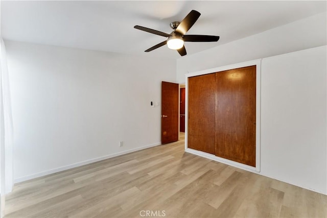 unfurnished bedroom with ceiling fan, light hardwood / wood-style floors, and a closet