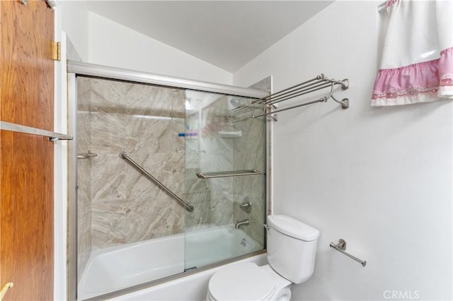 bathroom featuring toilet, vaulted ceiling, and combined bath / shower with glass door