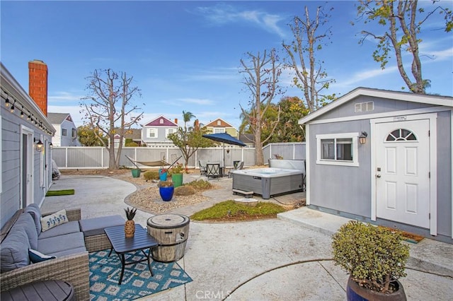 view of patio / terrace with outdoor lounge area, an outbuilding, and a hot tub