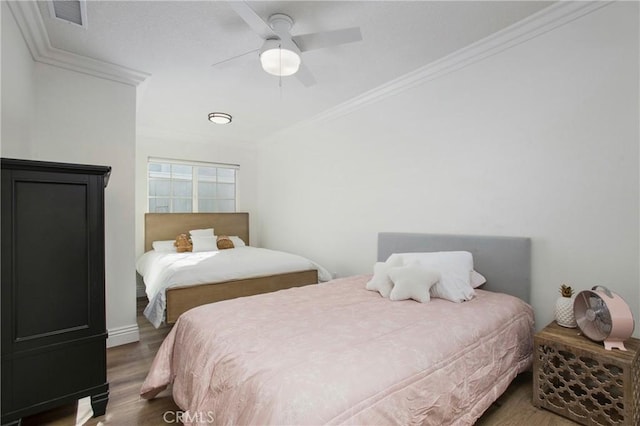 bedroom with dark hardwood / wood-style floors, ceiling fan, and crown molding