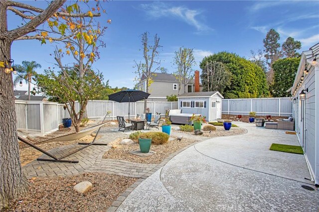 view of yard featuring a storage unit and a patio area