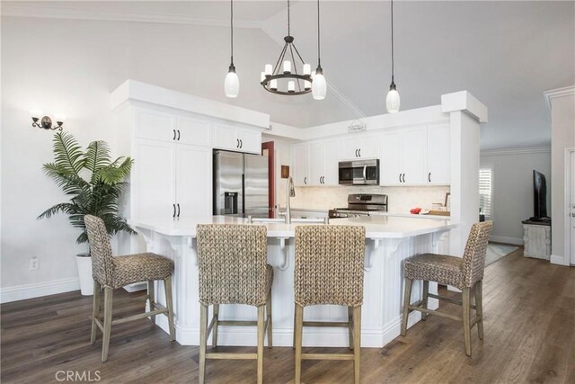 kitchen with stainless steel appliances, dark hardwood / wood-style flooring, decorative light fixtures, a breakfast bar, and white cabinets