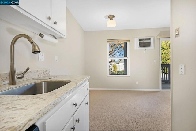 kitchen with light carpet, white cabinets, plenty of natural light, and sink