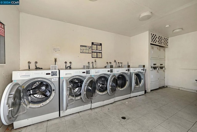 clothes washing area with washing machine and clothes dryer and light tile patterned floors