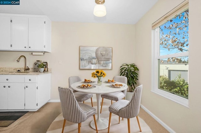 carpeted dining space with sink