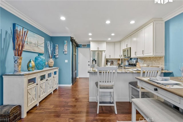 kitchen with white cabinets, crown molding, dark hardwood / wood-style floors, decorative backsplash, and stainless steel appliances