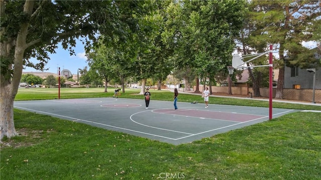 view of sport court with a lawn