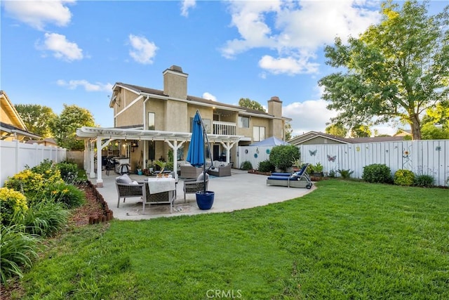 back of house with a pergola, a patio area, outdoor lounge area, and a lawn