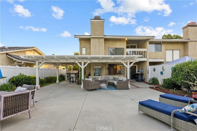 back of house featuring a pergola, a patio area, a bar, and an outdoor hangout area