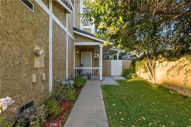 view of exterior entry with a lawn