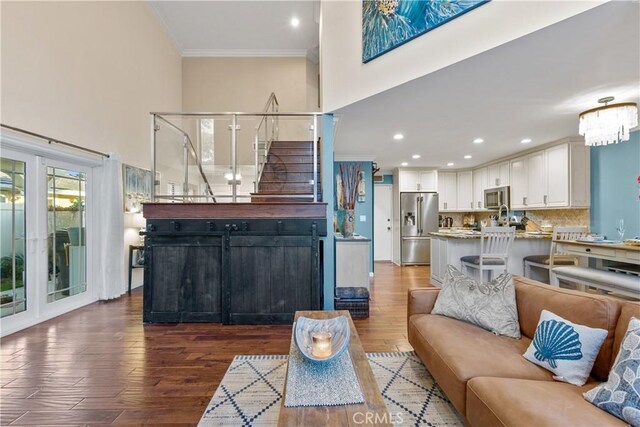 living room featuring crown molding, a chandelier, and dark hardwood / wood-style floors