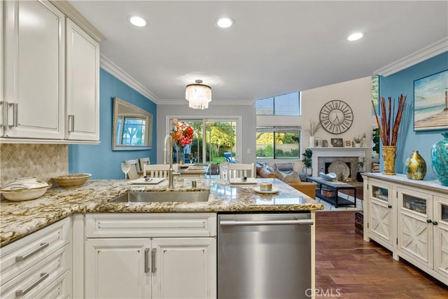 kitchen featuring sink, ornamental molding, stainless steel dishwasher, and white cabinets