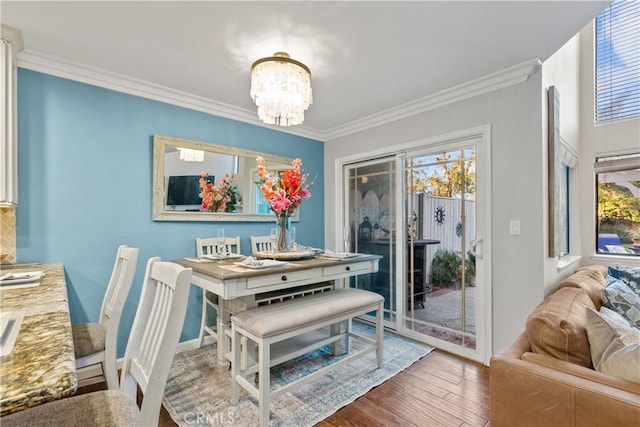 dining room featuring ornamental molding, hardwood / wood-style floors, and an inviting chandelier