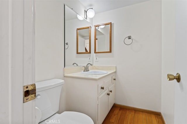 bathroom featuring hardwood / wood-style flooring, vanity, and toilet