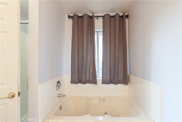 bathroom featuring a bath and plenty of natural light