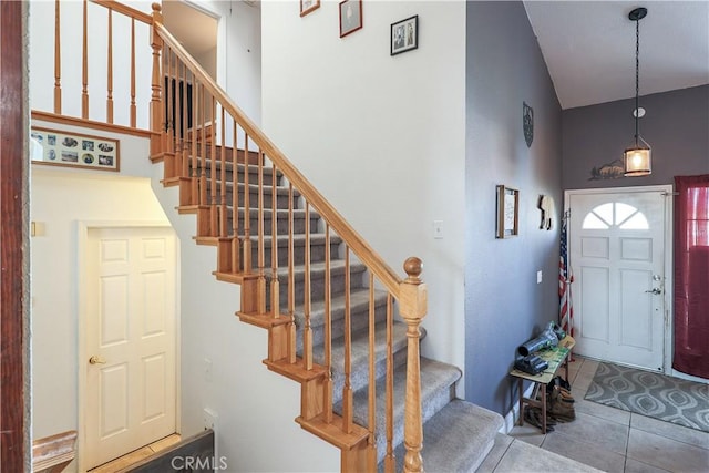 tiled entryway featuring high vaulted ceiling