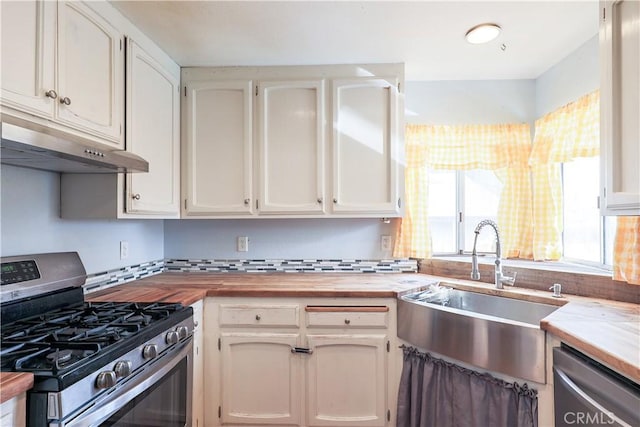 kitchen with appliances with stainless steel finishes, white cabinetry, butcher block counters, and sink