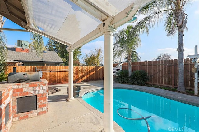 view of swimming pool featuring a patio, grilling area, and exterior kitchen