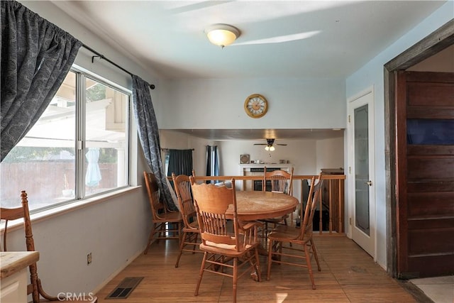 dining area with light wood-type flooring and ceiling fan