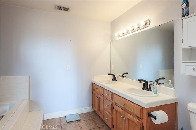 bathroom with a tub to relax in, tile patterned flooring, vanity, and toilet