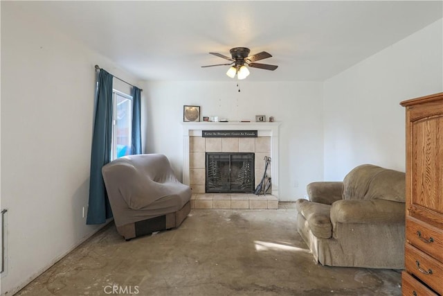 living room featuring concrete flooring, a tile fireplace, and ceiling fan