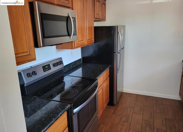 kitchen featuring appliances with stainless steel finishes and dark stone countertops