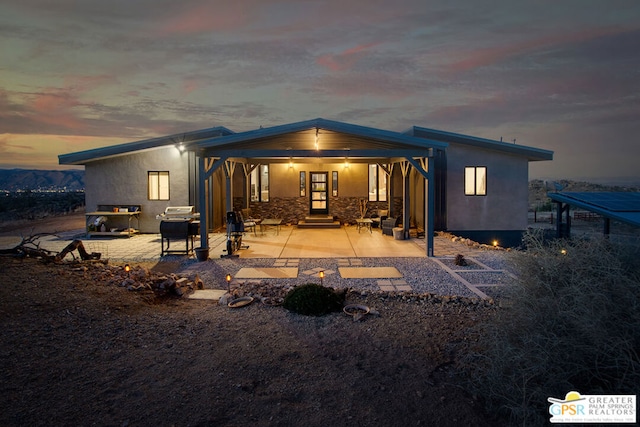 back house at dusk with a patio area and french doors