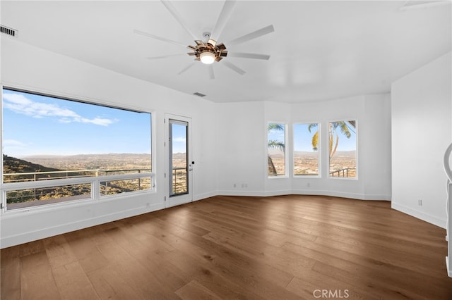 spare room featuring a mountain view, hardwood / wood-style floors, and ceiling fan