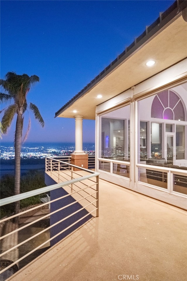 patio terrace at dusk featuring a balcony