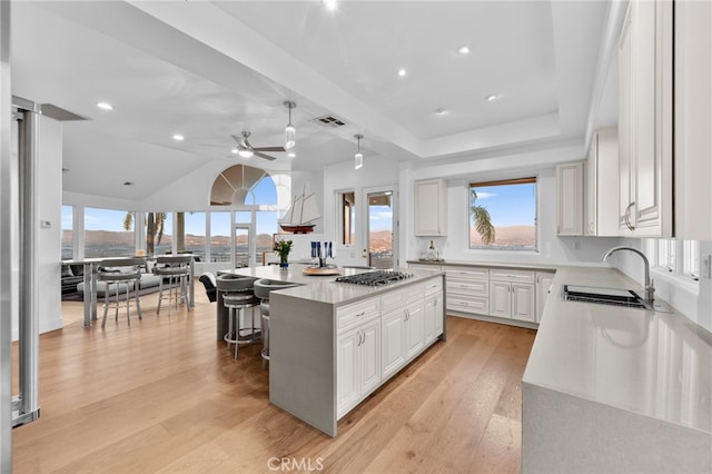 kitchen featuring white cabinets, a center island, plenty of natural light, and sink