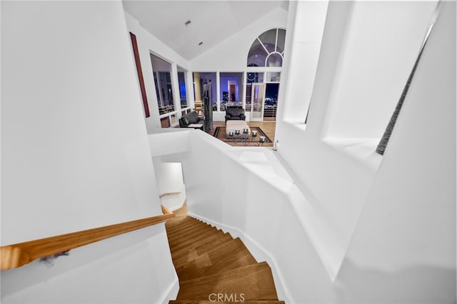 staircase with hardwood / wood-style flooring and lofted ceiling