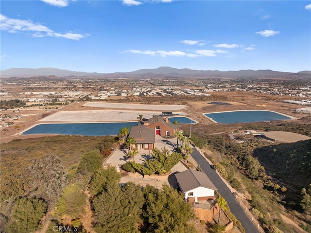 birds eye view of property with a water and mountain view