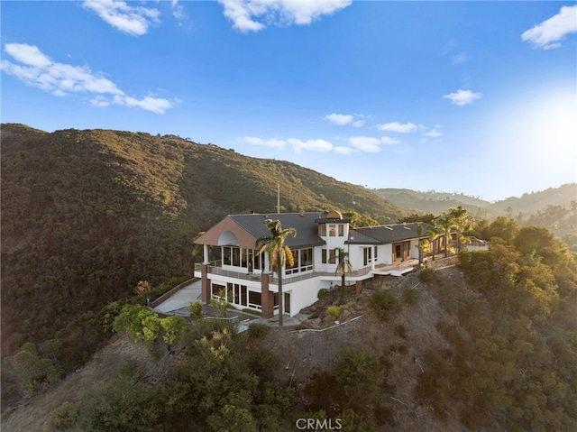 rear view of property with a mountain view and a balcony