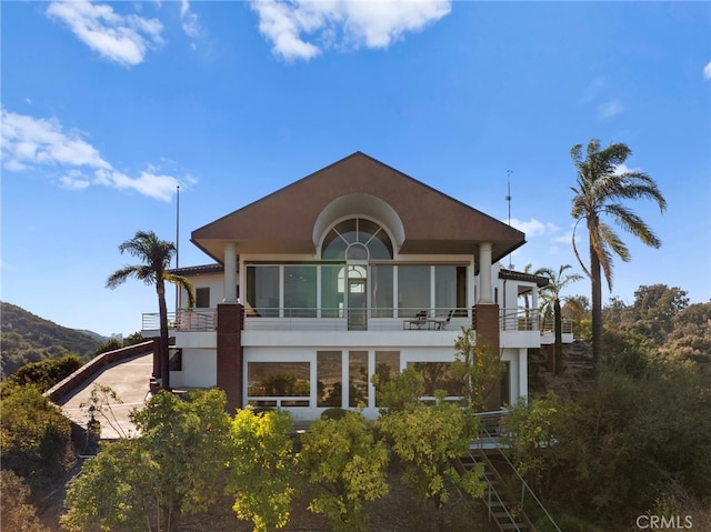 rear view of house featuring a mountain view and a balcony