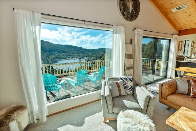 sunroom / solarium with a mountain view, lofted ceiling, and wood ceiling