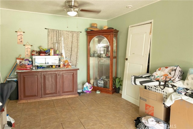 interior space with tile patterned floors and ceiling fan