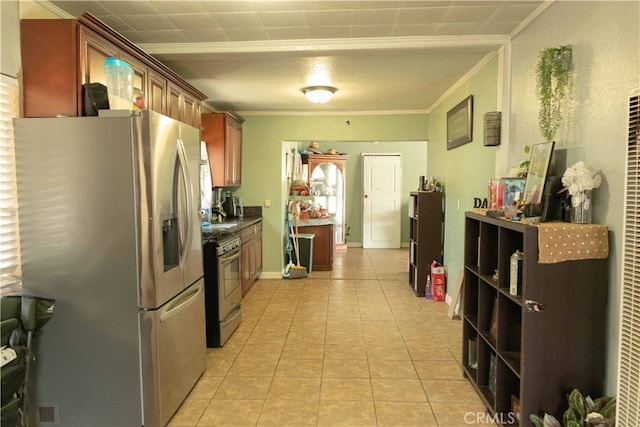 kitchen featuring light tile patterned floors, stainless steel appliances, and crown molding