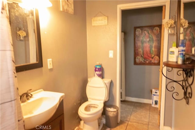 bathroom with toilet, vanity, and tile patterned floors