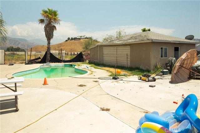 view of swimming pool with a mountain view and a patio