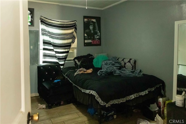 bedroom with crown molding and hardwood / wood-style floors