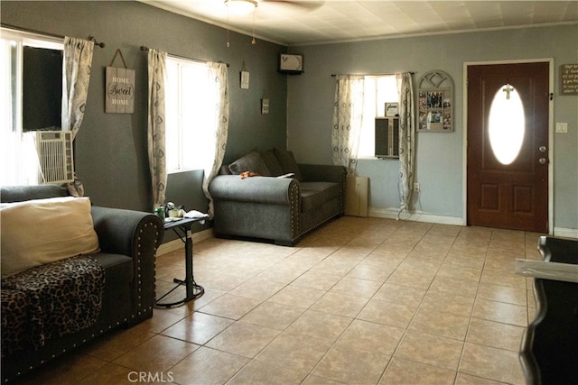 tiled living room with ceiling fan and crown molding