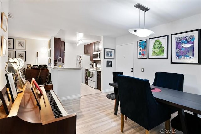 dining space with light hardwood / wood-style flooring and sink